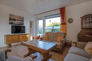 ein Wohnzimmer mit Tisch und Fernseher in der Unterkunft Ferienhaus Vogelnest in Berumbur