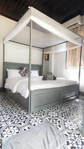 a bedroom with a canopy bed with white sheets at Dokchampa River View Villa in Nongkhiaw