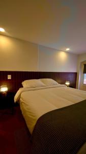 1 dormitorio con 1 cama grande con 2 luces. en Bendito Hostels, en Bogotá