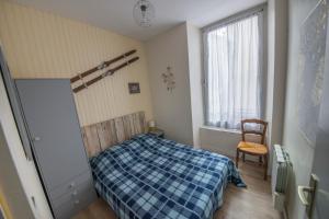een slaapkamer met een bed, een raam en een stoel bij Le 14 De Pic in Cauterets