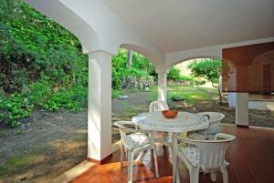 Un patio con una mesa y sillas en un porche. en Can Botana 3, en Cala de Sant Vicent