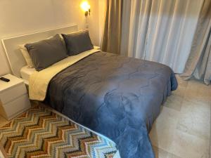 a bedroom with a large bed with a rug at Appartement Haut standing in Mohammedia