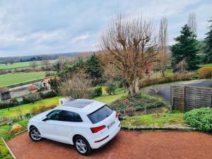 een witte auto geparkeerd op de oprit van een huis bij Villa Mel's in Bannay