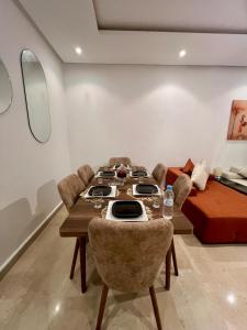 a dining room with a table and chairs and a couch at Pearl Rabat Stay 75 TV POOL in Rabat +18 photos