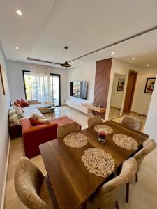 a living room with a wooden table and a couch at Pearl Rabat Stay 75 TV POOL in Rabat