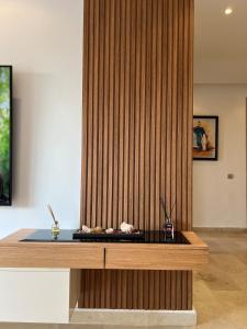 a room with a wooden wall with a desk at Pearl Rabat Stay 75 TV POOL in Rabat