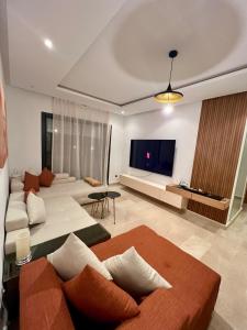 a living room with couches and a flat screen tv at Pearl Rabat Stay 75 TV POOL in Rabat