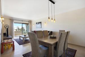 een eetkamer met een houten tafel en stoelen bij Villa Rosa Apartment in Portimão