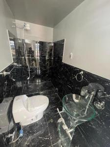 baño con aseo y mesa de cristal en HOSTElANDES, en San Antonio