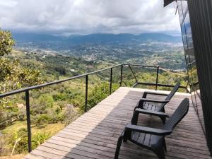um deque de madeira com duas cadeiras em cima em Luna Creciente Refugio de Luz y Naturaleza em Silvania