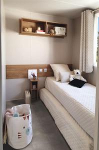 une chambre avec un lit avec un ours en peluche dessus dans l'établissement FMLODGE- sables du midi mobilhome les glycines, à Valras-Plage