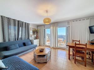 ein Wohnzimmer mit einem blauen Sofa und einem Tisch in der Unterkunft Garbinell A - Piso muy bonito, Vistas al mar espec in Roses