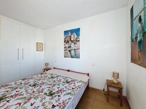 ein Schlafzimmer mit einem Bett und einem Gemälde an der Wand in der Unterkunft Garbinell A - Piso muy bonito, Vistas al mar espec in Roses