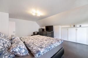 シュライデンにあるFerienhaus Oleftal Nationalparkのベッドとソファのある寝室