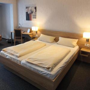 a bedroom with a large bed with two pillows at Hotel und Restaurant Teegen in Leezen