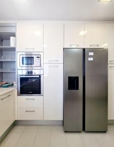 DílarにあるSuite y mucho másの- ステンレス製の冷蔵庫(白いキャビネット付)