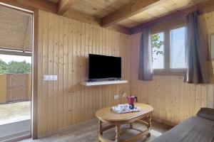 un salon avec une télévision et une table dans l'établissement Casa el mirlo, à Conil de la Frontera