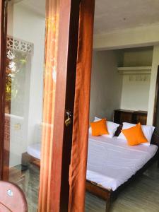 a bedroom with a bed with orange pillows at Ameeila Villa in Kandy +7 photos