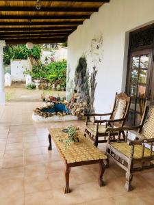 a living room with chairs and a table and a fireplace at Ameeila Villa in Kandy