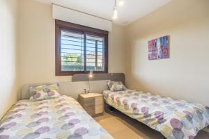 a bedroom with two beds and a window at Terrazas de Campoamor Sunrise in Orihuela +18 photos