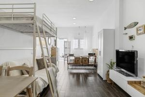 a living room with a bunk bed and a television at La Casita Blanca in Barbate