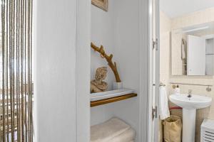 a bathroom with a statue of a woman on a shelf at La Casita Blanca in Barbate +14 photos