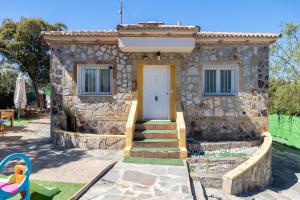 a stone house with a white door and a playground at La Casa De Trasto in Ituero y Lama