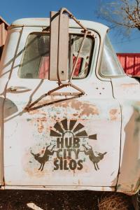 an old white truck with a hot dog shops sign on it at Hub City Silos in Doud
