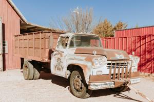 an old truck parked next to a red barn at Hub City Silos in Doud +12 photos