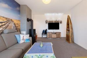 un soggiorno con un divano e una TV di Seeschwalbe a Olpenitz