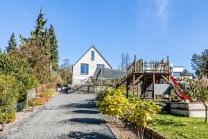 a garden with a house and a playground at Architektenhaus mit Pool und Sauna in Buchholz in der Nordheide