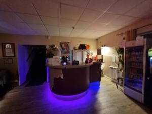 una habitación con un bar con luces azules. en Amadour Hôtel, en Rocamadour 31 fotos más