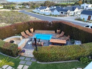 an aerial view of a backyard with a swimming pool and patio furniture at Yellow Wood 1 in Hermanus