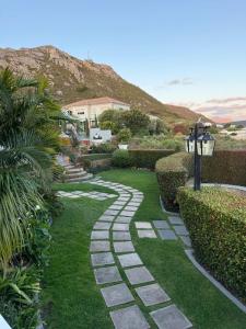 a garden with a walkway with grass and bushes at Yellow Wood 1 in Hermanus
