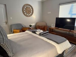 a bedroom with a bed and a flat screen tv at Yellow Wood 1 in Hermanus