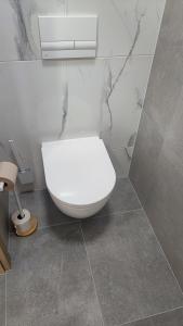 aseo blanco en un baño con paredes de mármol en Modern studio in a residence with parking, en Myjava