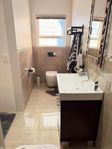 a bathroom with a sink and a toilet at Yellow Wood 1 in Hermanus +19 photos