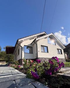 Una casa con flores moradas en el frente. en Charming Little House in Brad, en Brad