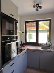 una cocina con fregadero y estufa horno superior en Charming Little House in Brad, en Brad