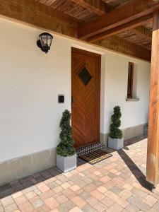 a wooden door on the side of a house with two plants at Ferienwohnung Kleines Wiesental in Kleines Wiesental