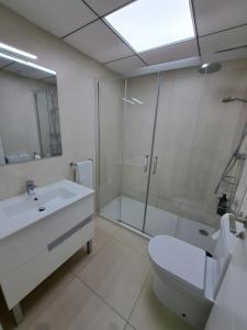 a bathroom with a toilet and a sink and a shower at Paraiso Duna 2 Beach Views in Morche