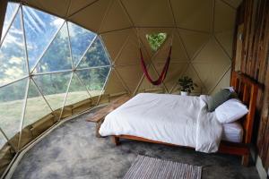 a bedroom with a bed in a dome tent at Eco Domes Couples Getaway - Waterfall and Mountain Views in Jarabacoa