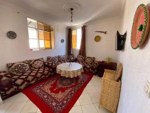 Tamraght OuzdarにあるRed Carpet Surf Camp , Surf , Chill & Ocean Views in Tamraghtのソファとテーブルのあるリビングルーム