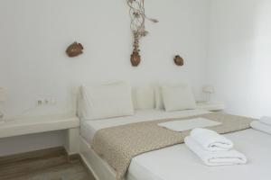 a white bedroom with a bed and a sink at Sorokos Koufonissia in Koufonisia
