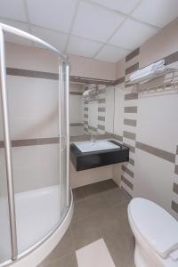 a bathroom with a shower and a toilet and a sink at Van Ha Boutique Hotel Etown - Nhà Ga T3 in Ho Chi Minh City