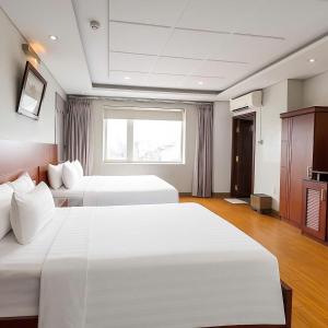 a hotel room with two beds and a window at Van Ha Boutique Hotel Etown - Nhà Ga T3 in Ho Chi Minh City