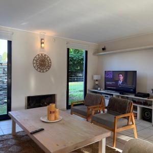 a living room with a table and a tv at Sumergite en una gran piscina o jacuzzi in Gualeguaychú