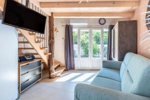 サン・ドニ・ドレロンにあるLe Petit Appartement de Saint-Denisの青いソファとテレビのあるリビングルーム