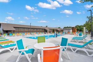 una piscina con sillas coloridas, mesas y sillas en Lakefront Oasis - Amazing Views, en Kimberling City