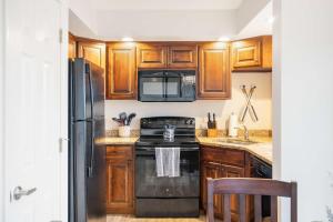 cocina con armarios de madera y estufa negra en Lakefront Oasis - Amazing Views, en Kimberling City